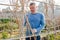 Male horticulturist working with wooden girders in garden