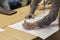 Male Host Writing on a Big Paper Sheet in Front of Group of People