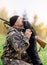 Male hunter with a gun on his shoulder hugging a Russian spaniel dog