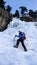 Male ice climber in a blue jacket on a gorgeous frozen waterfall climbing in the Alps in deep winter