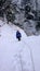 Male ice climber on a frozen ice fall covered in deep snow