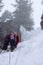 Male ice climber in heavy snowfall and bad weather climbing a frozen waterfall in the Swiss Alps