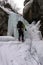 Male ice climber rappelling on a frozen waterfall in the Swiss Alps