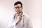 Male indian doctor in white coat and stethoscope trimming beard with trimmer. doctor styling theme image