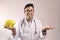 Male indian doctor in white coat and stethoscope with a yellow piggy bank and medicine pills in hand. medical expense concept