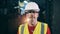 Male industrial worker in a hardhat is looking at the camera