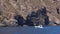Male on an inflatable runabout is floating along mountain of Lipari Island, Mediterranean sea. Summer sunny day. Sicily