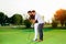 Male instructor showing woman to play golf