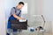 Male janitor cleaning computer in office