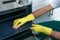 Male janitor cleaning oven tray with sponge in kitchen