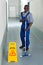 Male Janitor Mopping In Corridor