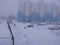 a male janitor with a shovel goes in the yard of the house in winter cleaning the snow