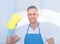 Male janitor using a sponge to clean a window