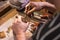 A male jeweler fixes a precious zirconium stone into a silver earring.