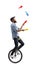 Male juggler on a unicycle juggling with clubs