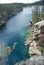 Male jumping off cliff into horseshoe lake