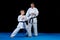 Male karate instructor training little children in dojo