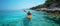 Male kayaker in pristine blue waters, serene summer scene, outdoor adventure, rear view