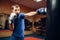 Male kickboxer hits the punching bag in gym