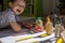 Male kid playing wooden bricks and dinosaurs drawing shadow on paper early development education