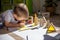 Male kid playing wooden bricks and dinosaurs drawing shadow on paper early development education