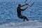 A male kiteboarder rides on a board on a large river.