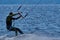 A male kiteboarder rides on a board on a large river.