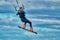 A male kiter jumps over a large lake. Close-up