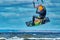 A male kiter jumps over a large lake. Close-up