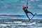 A male kiter jumps over a large lake. Close-up