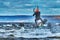 A male kiter jumps over a large lake. Close-up