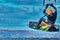 A male kiter jumps over a large lake. Close-up