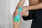 Male knee with applied physio tape, indoors