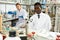 Male lab technicians with different glass tubes, girl on background