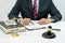 A male lawyer or notary working with contract papers, book and wooden gavel on table in courtroom, Law and Legal services concept