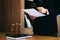 Male lawyer reading legal contract agreement and examining documents with magnifying glass in courtroom