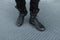 Male legs closeup. Stylish young man in trendy jeans in vintage black leather boots. Details of everyday look. Old-fashioned style