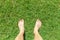 Male legs stand on green grass lawn