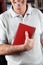 Male Librarian Holding Book In Library