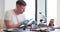 Male looks at printed circuit board with magnifier glass