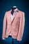 Male luxurious classic suit checkered pink jacket on dummy or mannequin on blue background