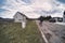 A male man with a german shepherd dog is walking on the side of the road in a country side. Rear view. a loyal friend of man.