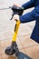 Male man hands and electric scooter with yellow Whoosh sign parked in wet square, close-up, vertical photo. Astana Nur-Sultan,