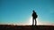 Male man worth it tourist with backpack with dog stands on top of a mountain. slow motion video. man silhouette at