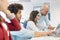 Male manager and female operator having discussion with colleagues in foreground at office