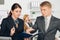 Male manager instructs female employee in office