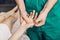 A male massage therapist puts pressure on a sensitive point on a woman`s hand.