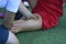 Male massagist hands massaging leg of the woman football player on the soccer field