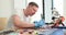 Male master unscrews printed circuit board of broken laptop