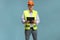 Male mature engineer with a safety vest and hardhat holding a clipboard